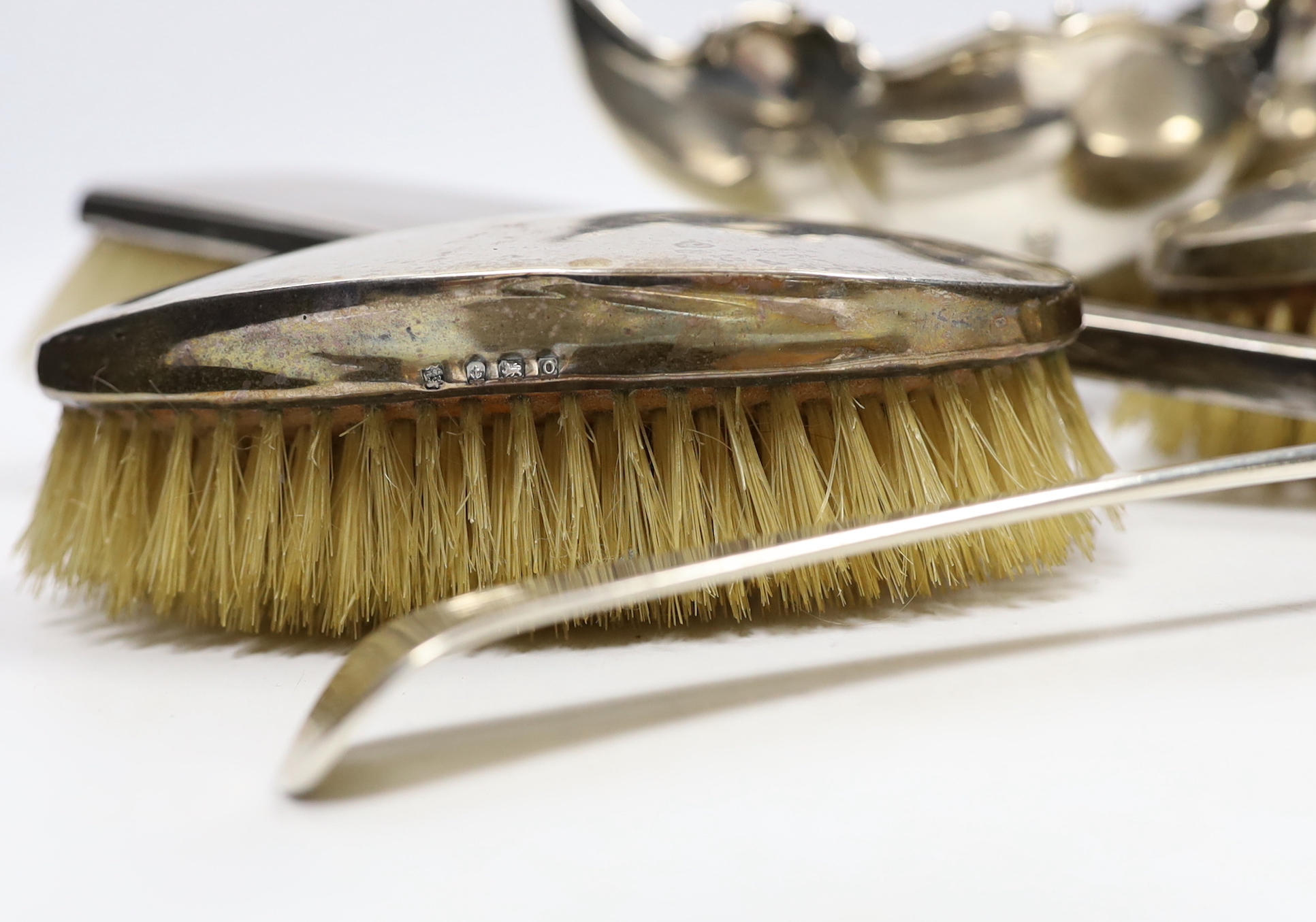 A George III silver Old English pattern basting spoon, with base marks, date letter rubbed, an Edwardian silver bowl and four silver mounted brushes.